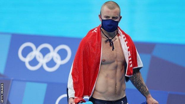 Adam Peaty poolside at Tokyo 2020 wearing a mask