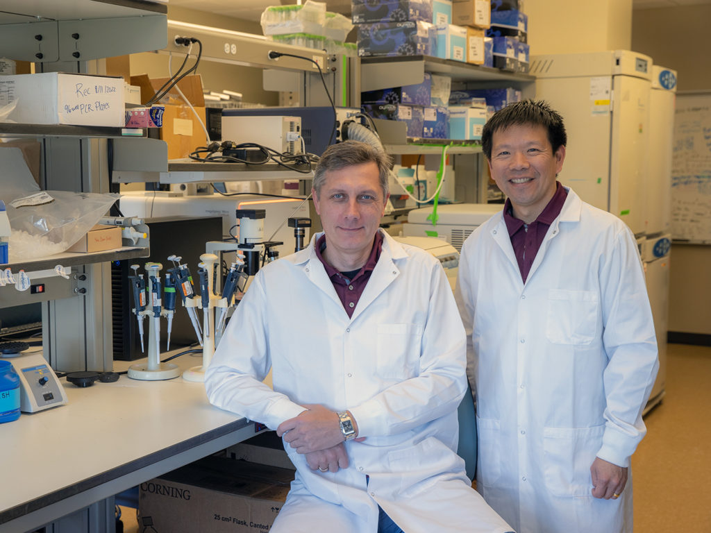 Drs. Ivan Rusyn and Weihsueh Chiu wearing white lab coats in a lab